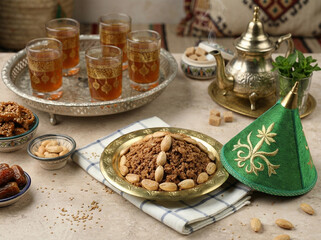Traditional Moroccan Ramadan dish Sellou on the table with tea and sweets