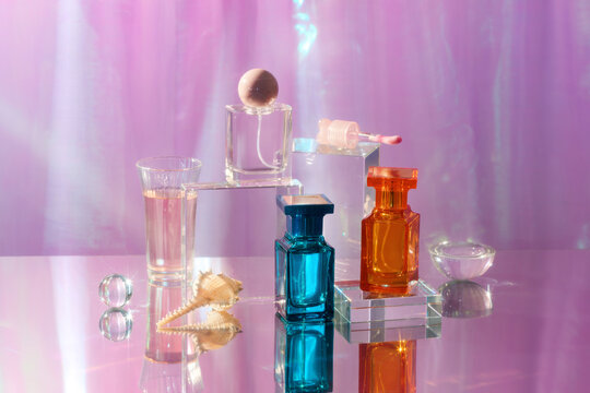 Elegant perfume bottles and glass objects on a reflective surface