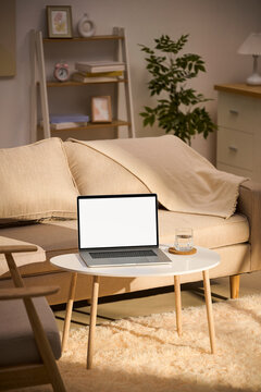 Cozy living room with laptop on a round table and a comfortable sofa