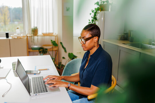 Woman working remotely from home using laptop