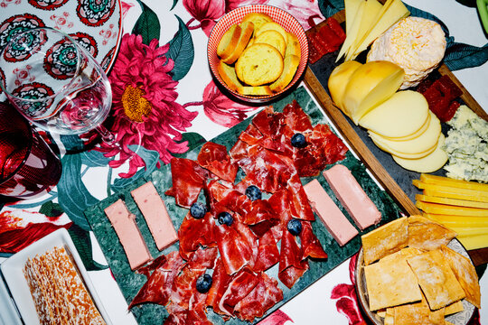a richly set table with cheeses, iberian ham, pate and bread