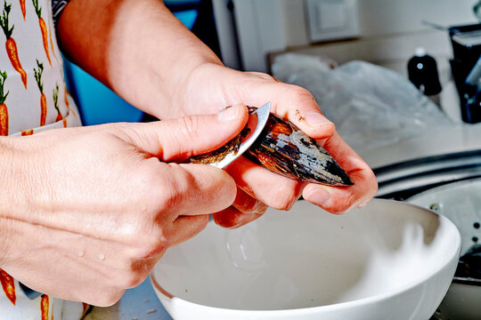 trimming a fresh mussel with with a short knife