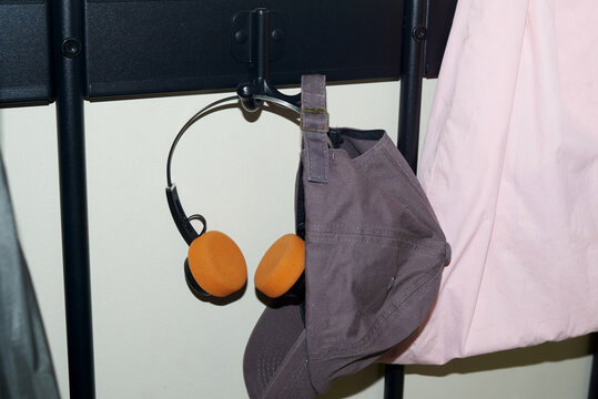 Headphones and cap hanging on a rack in a room
