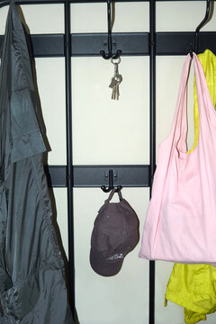 Clothing, cap and keys hang on hooks by a rack 