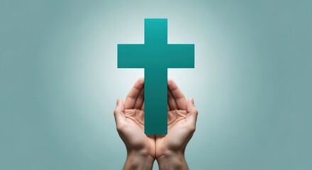Obraz premium Person holding a teal cross in their hands symbolizing faith and spirituality in a serene and calming environment with a soothing light blue background