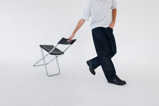 Casual Man With Folding Chair In Studio