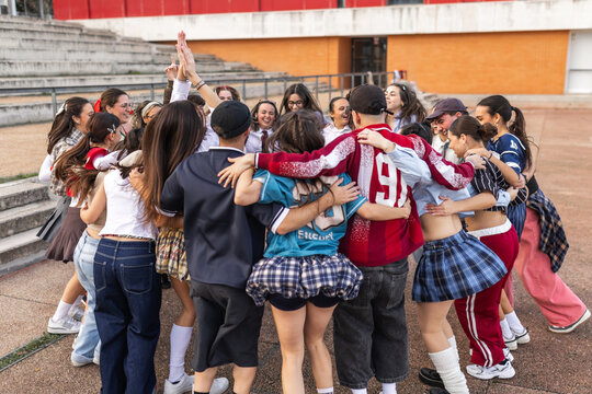 Large group of students celebrating together in school courtyard