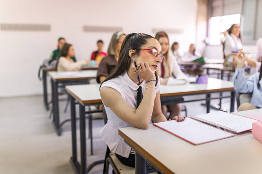 Bored student sitting at desk in classroom
