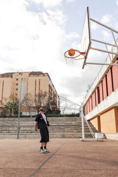 Student scoring a basketball shot in school playground
