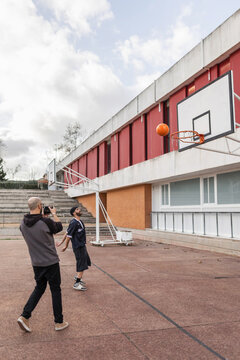 Videographer filming basketball shot going through hoop