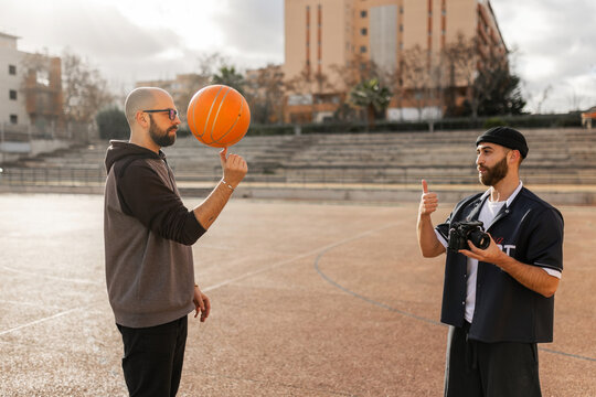 Student learning basketball trick with in school courtyard