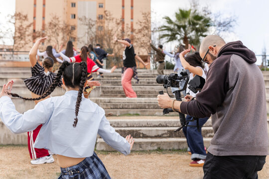 Videographer filming student dance choreography at school
