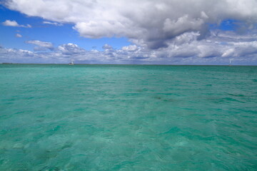 Obraz premium Motorboat anchored in the serene turquoise ocean beside a sandy beach