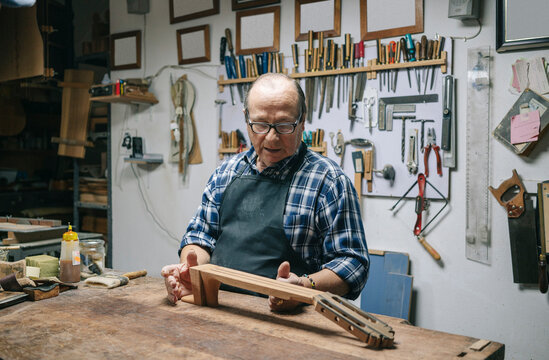 Luthier carefully crafting guitar in workshop