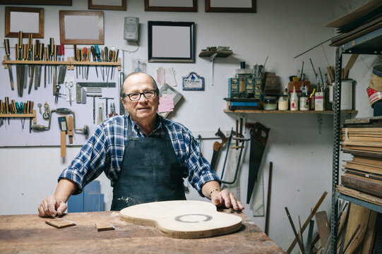 Luthier making a classical guitar in his workshop