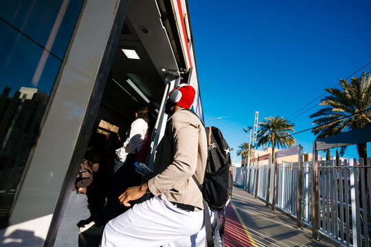 Man boarding modern train from urban platform