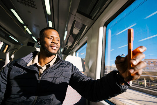 Man travelling by train and taking a photograph