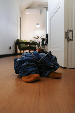 Jeans and socks lying empty on floor at home