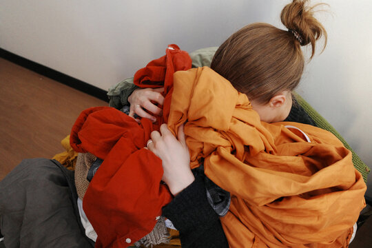 Woman feeling overwhelmed with large pile of laundry