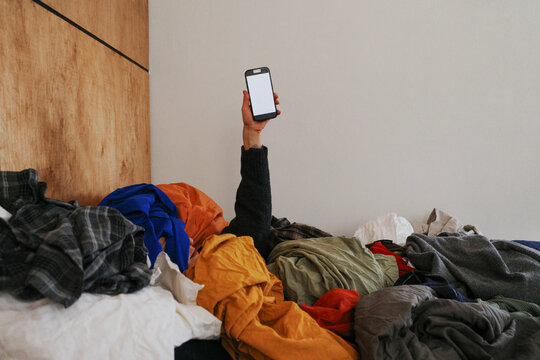 Buried under laundry holding a smartphone finding help