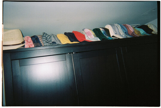caps lined up on top of a wardrobe, 35mm film