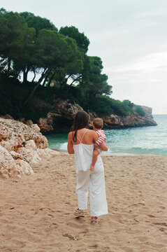 Woman Holding Child On Sandy Beach Film Photo