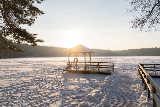 Winter Morning at a Lakeside Pavilion With Snow and Sunlight