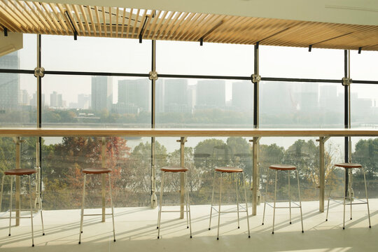 Window view from a cafe with bar stools facing a city skyline