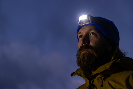 Portrait of hiker with headlamp in dark 