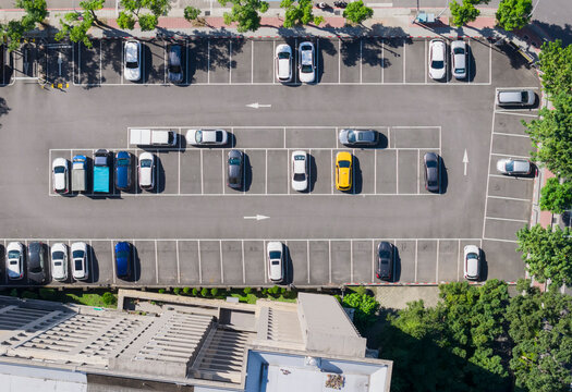 Aerial View of Urban Parking Lot with Parked Cars and Shadows