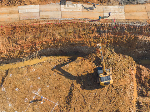 Aerial Excavation Site with Workers and Heavy Machinery
