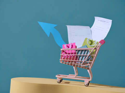 Shopping cart with receipts and arrow showing financial growth