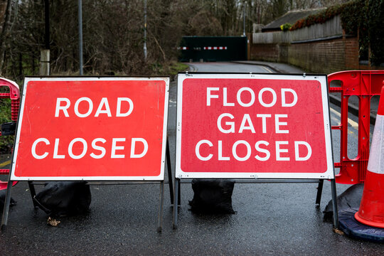 Red flood barrier warning signs on a road
