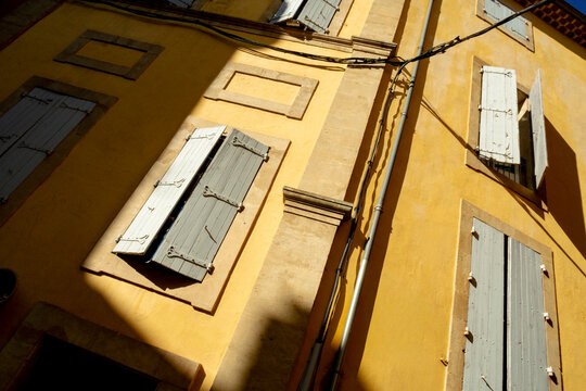Yellow Facade with Open Shutters