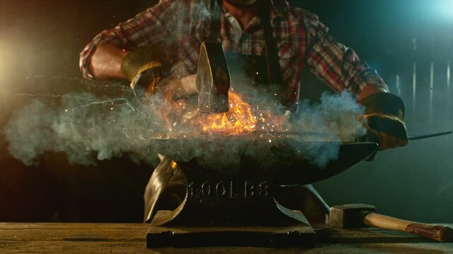Cinematic close-up of blacksmith forging glowing hot iron on anvil with sparks flying. Shot in dramatic lighting on dark background with high-speed camera at 1000fps. Camera in motion. Speed Ramp.