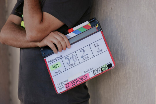 Film crew member holding a clapperboard on set