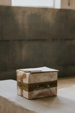 Cardboard package with brown tape on stone bench