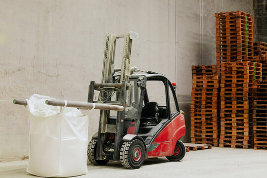 Forklift in warehouse with large bag and pallets