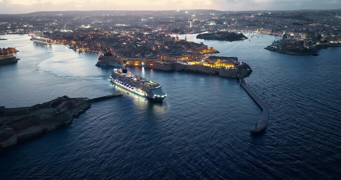 Malta, Valletta - 11.10.2025: Cruise luminous ship leaves the port of Valletta at night. Malta 
