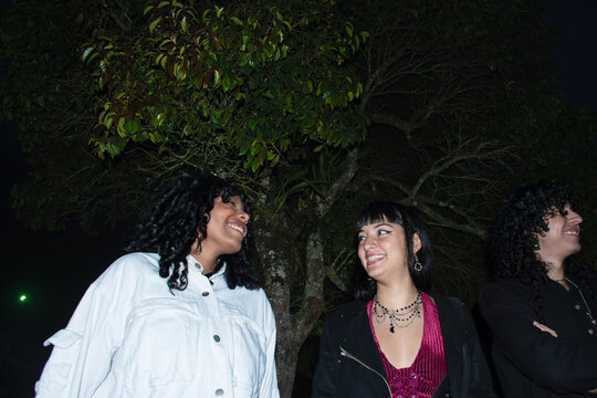 Friends Enjoying Night Time Conversation Under a Tree