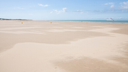 personne seule sur la plage avec un bateau au loin, vacances. Ferry sur la Manche partant pour l'Angleterre depuis la grande plage de Calais