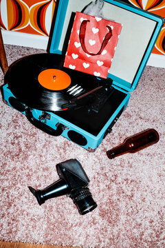 cocaine lines on a vinyl near a bottle, a camera and a heart gift bag