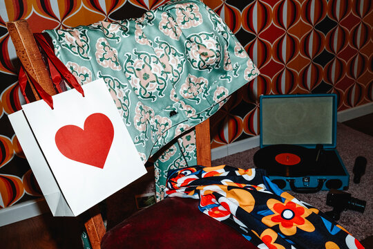 folded clothes beside a paper gift bag with a red heart