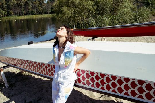 young woman near a kayak on the lake shore