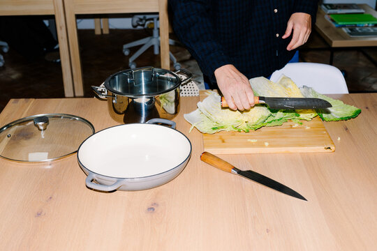 Unknown man chopping cabbage in his kitchen