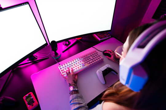 Female gamer playing on pc with dual monitor