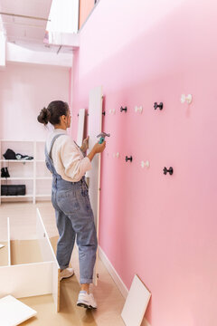 Woman positioning wardrobe panel against wall