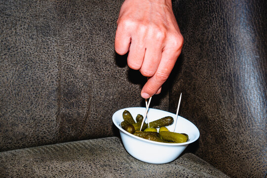 a man picking an olive with a toothpick