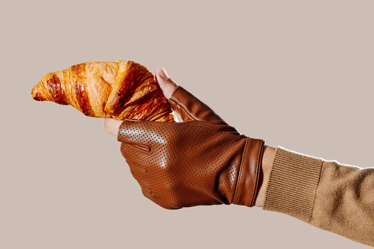 a man grips a croissant like it were a handgun