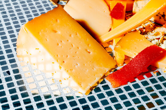 a semi hard cheese wedge next to quince cheese